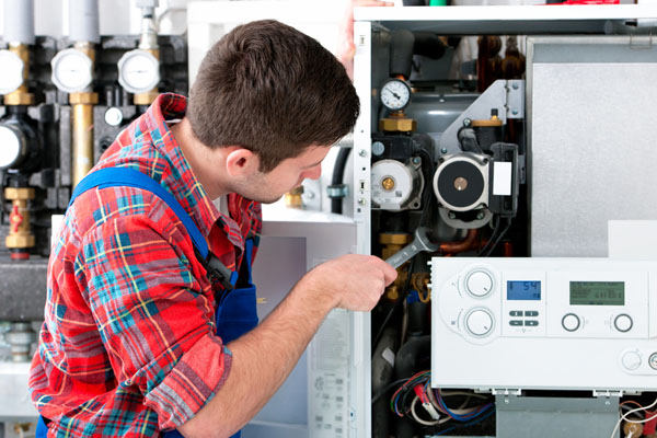 HVAC technician inspecting and repairing boiler controls in Surprise