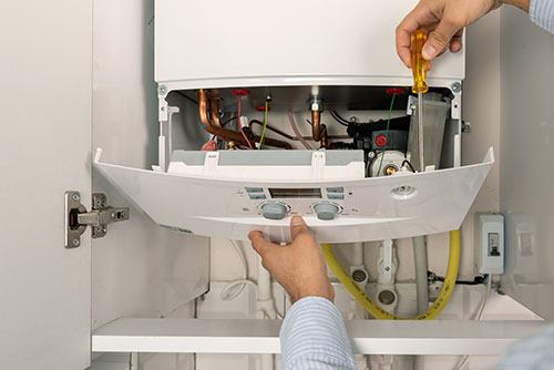 HVAC technician repairing an indoor boiler in Surprise