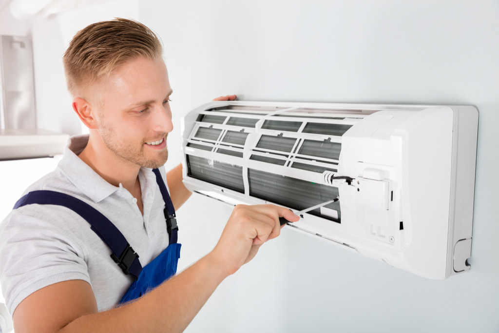 HVAC technician performing ductless air conditioning maintenance in Surprise