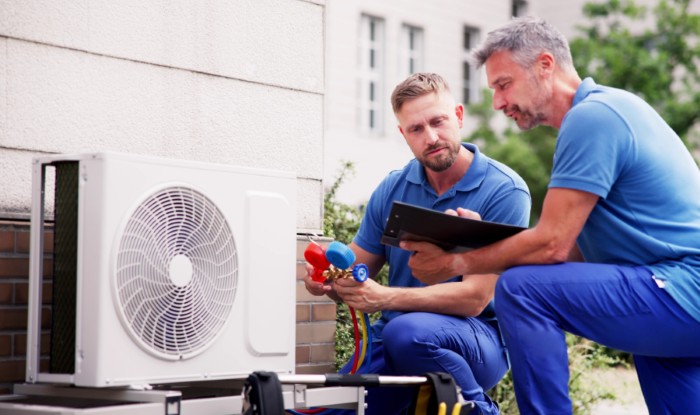 HVAC technicians installing an outdoor air conditioning unit in Surprise