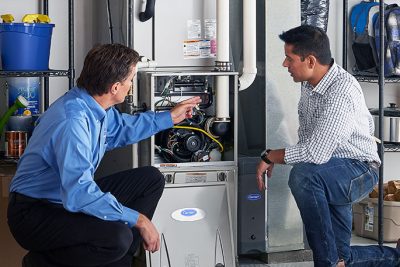 65df8c11f3e4c468cbd351a5_furnace repair vs replacement – Copy HVAC technician explaining furnace repair and maintenance to a homeowner in Surprise, AZ