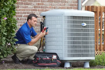 design-air-heating-and-air-conditioning-decatur-il-05 – Copy HVAC technician inspecting an outdoor air conditioning unit in Surprise, AZ