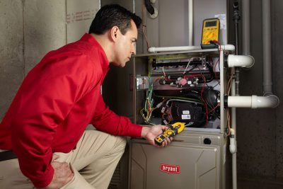 furnace repair Heating and air conditioning technician servicing an indoor furnace in Surprise, AZ